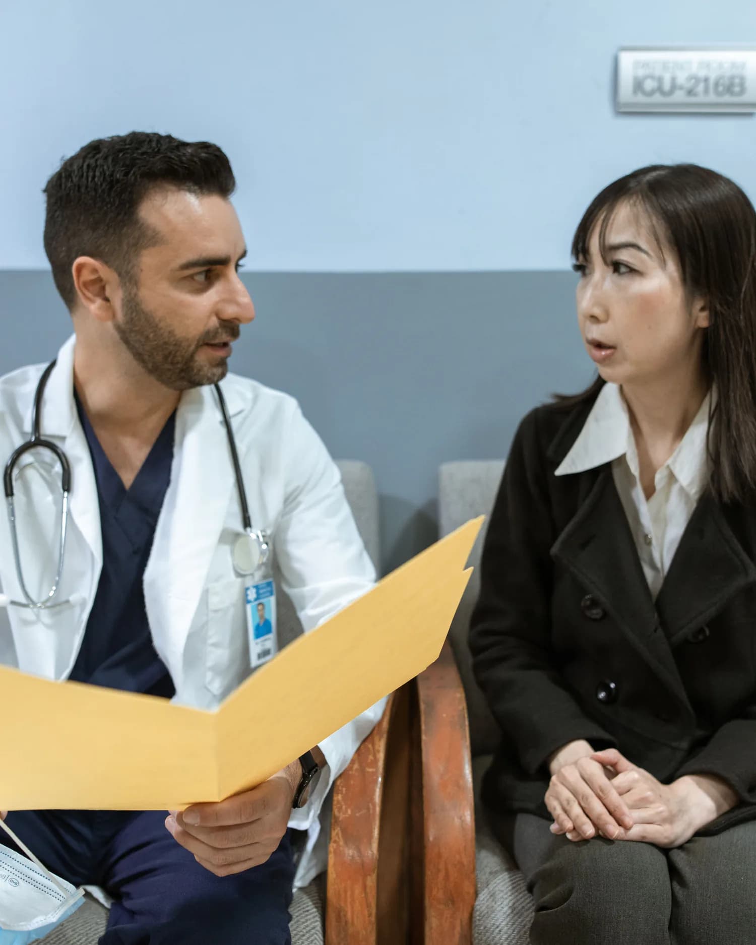 Profissional de saúde e paciente adulto conversando durante uma consulta